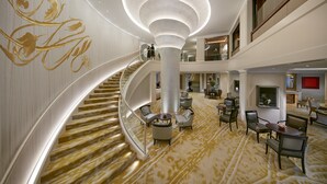 A spacious lobby with a grand staircase, comfortable seating areas, and a modern chandelier. - Mandarin Oriental, Munich (Munich)