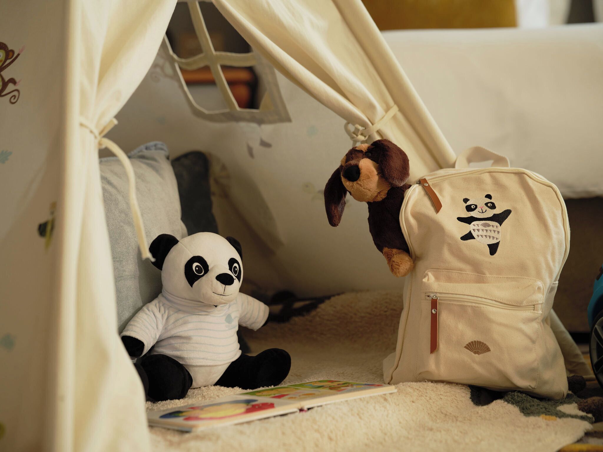 Ein Zelt mit einem Panda-Plüschtier und einem Rucksack mit Panda-Motiv.