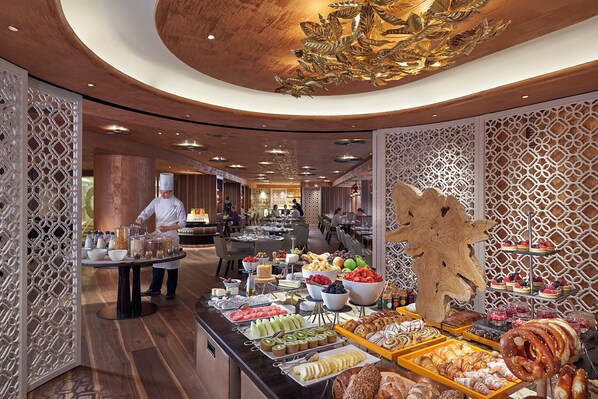 A buffet area with a variety of food items and a chef preparing food. - Mandarin Oriental, Munich (Munich)
