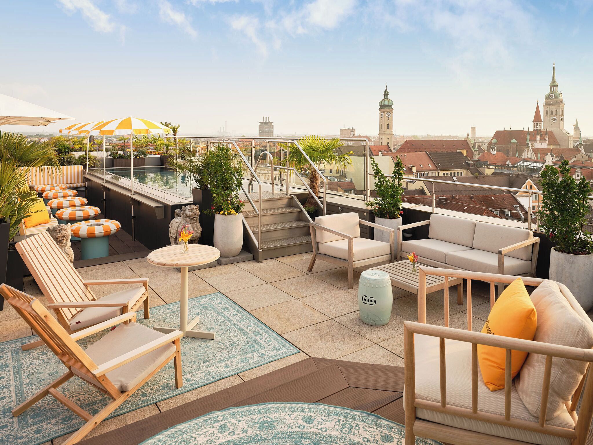 Terraza en la azotea con mobiliario exterior, piscina y vista a la ciudad.