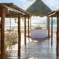 Dine under a thatched-roof gazebo with a view of the ocean.