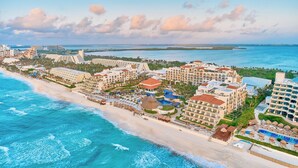 Un complejo turístico frente al mar con villas privadas, una zona de piscina y vistas al océano.