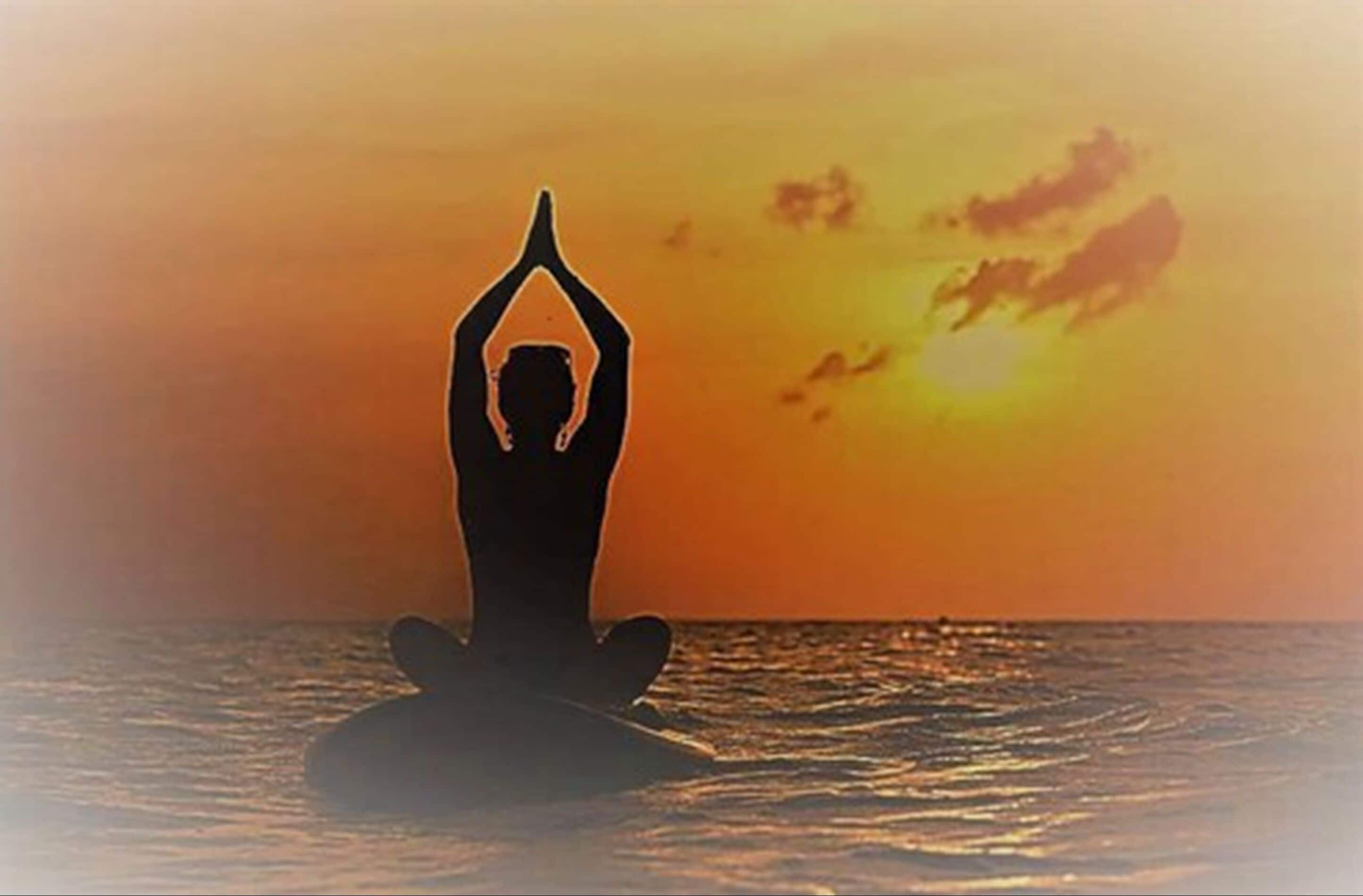 A silhouette of a person meditating on a floating platform with a sunset in the background.