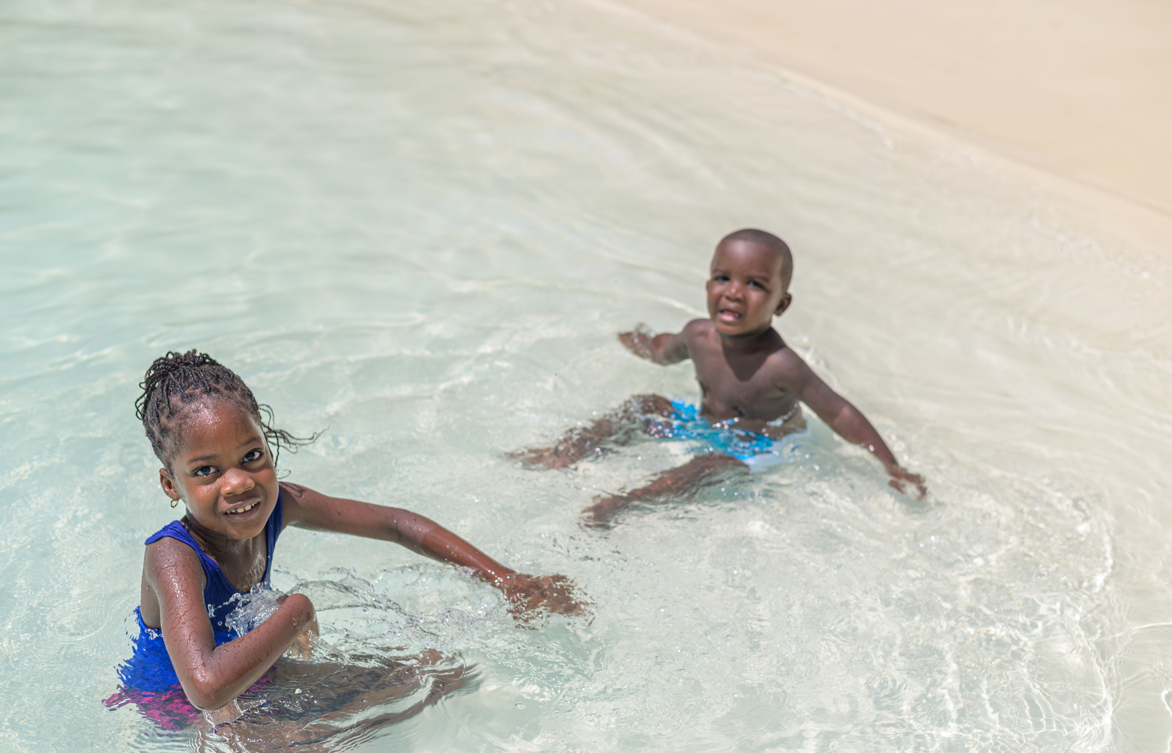 Una piscina al aire libre, sombrillas, sillones reclinables de piscina