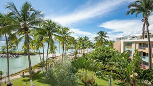 Un resort con palmeras, piscina y vista al mar.