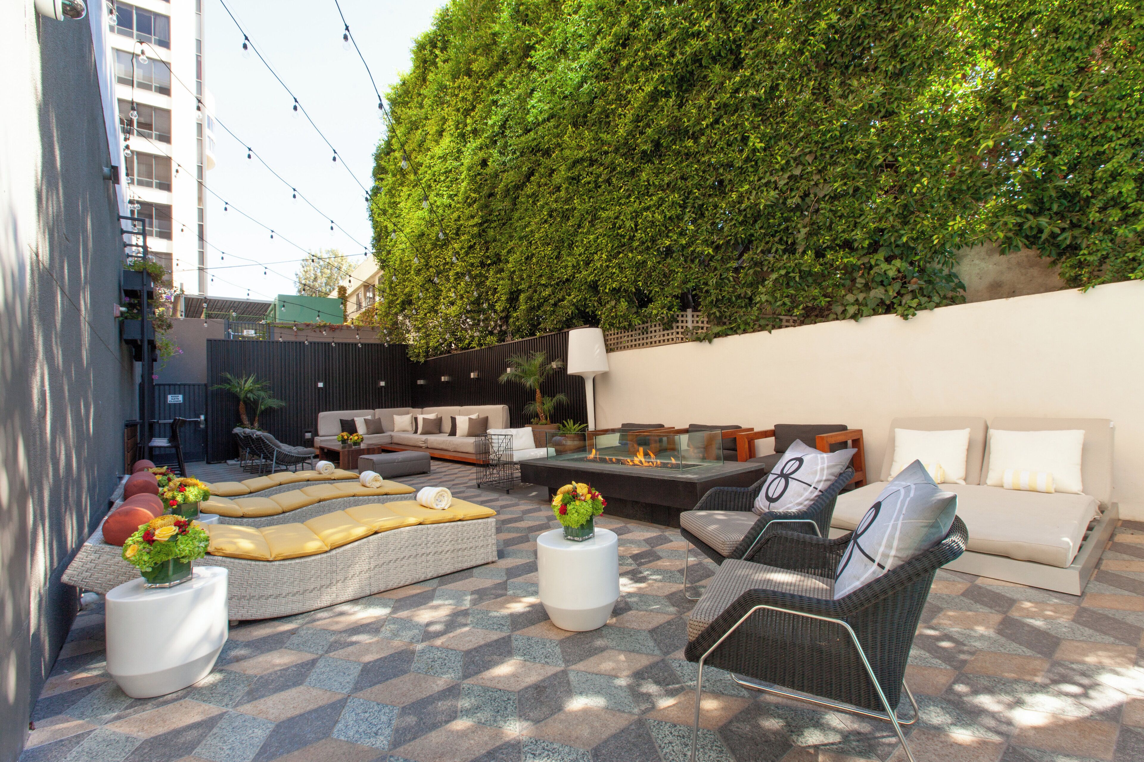 Un espacio exterior con sofás, sillones y una chimenea.