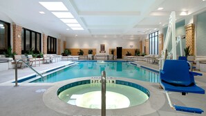 Piscina interior con una profundidad de 1 metro 17 centímetros, rodeada de sillones de descanso y plantas en macetas.