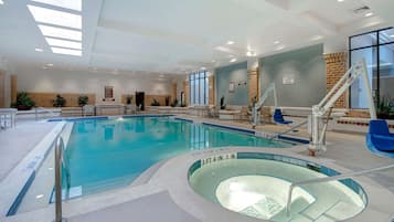 Una piscina interior con un trampolín y un puesto de socorrista.