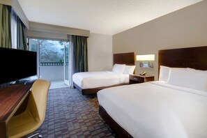 A hotel room with two beds, a desk, a chair, a television, and a window with curtains. - Embassy Suites by Hilton Jacksonville Baymeadows (Jacksonville)
