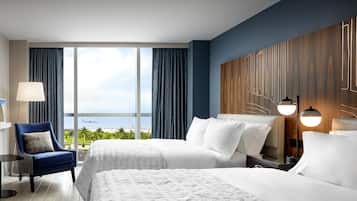 Habitación de hotel con dos camas, vista al océano y una decoración moderna.