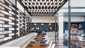 Una biblioteca moderna con estanterías, zonas de estar y un espacio para comer.