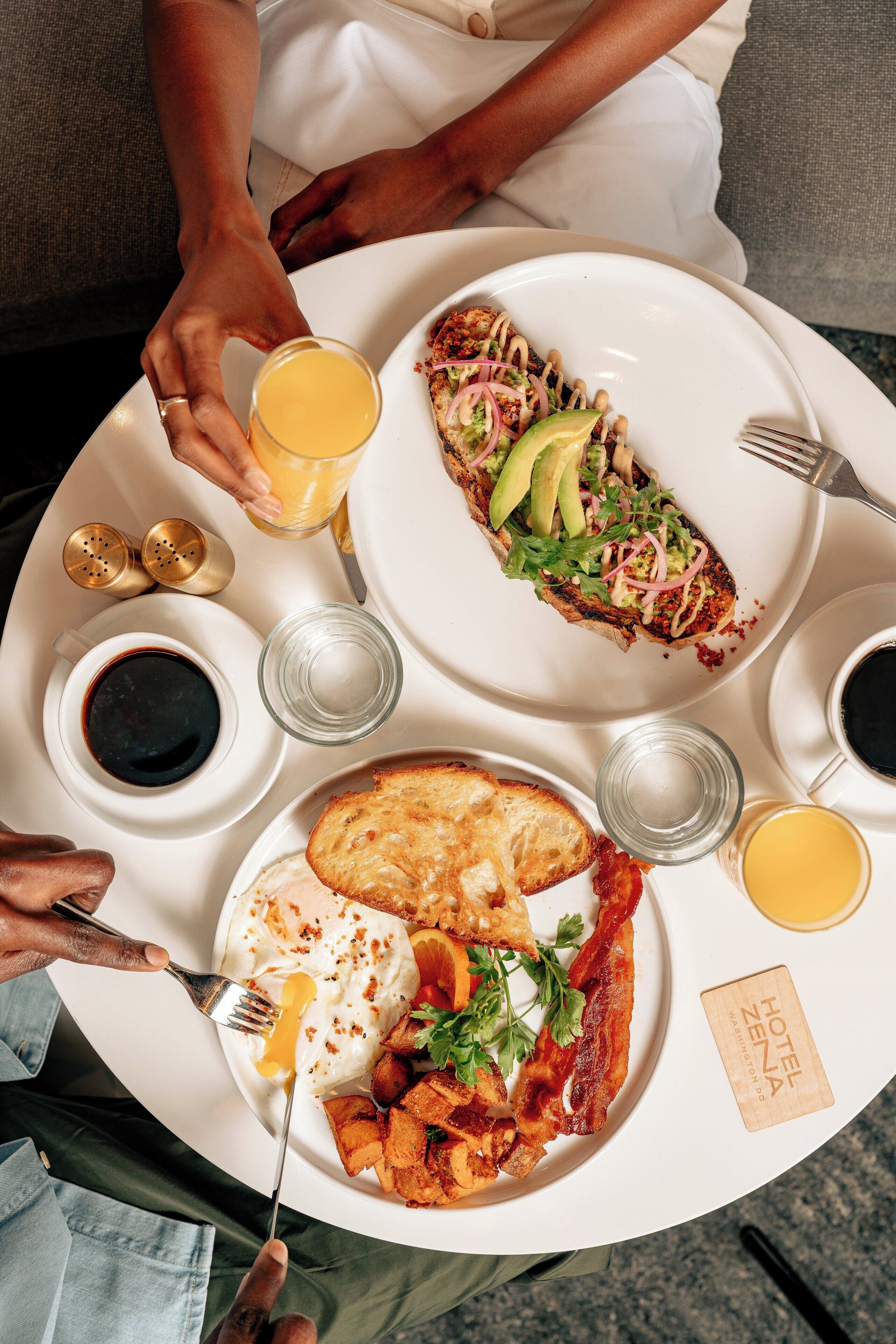 A breakfast tray with toast, eggs, bacon, and a salad on a white plate.