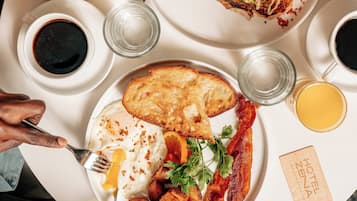 A breakfast tray with toast, eggs, bacon, and a salad on a white plate.