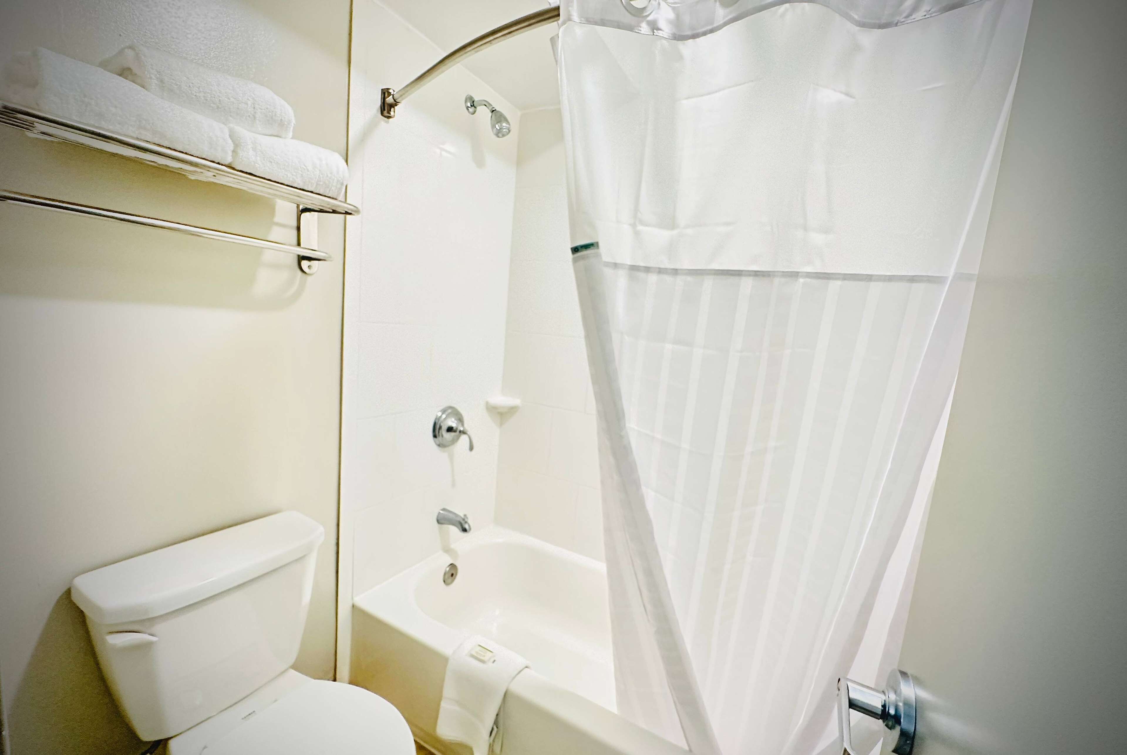 Un baño con inodoro, bañera y cortina de ducha.