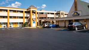 Un hôtel Days Inn doté d’un parking, de plusieurs étages et d’une décoration distinctive aux couleurs jaune et beige.
