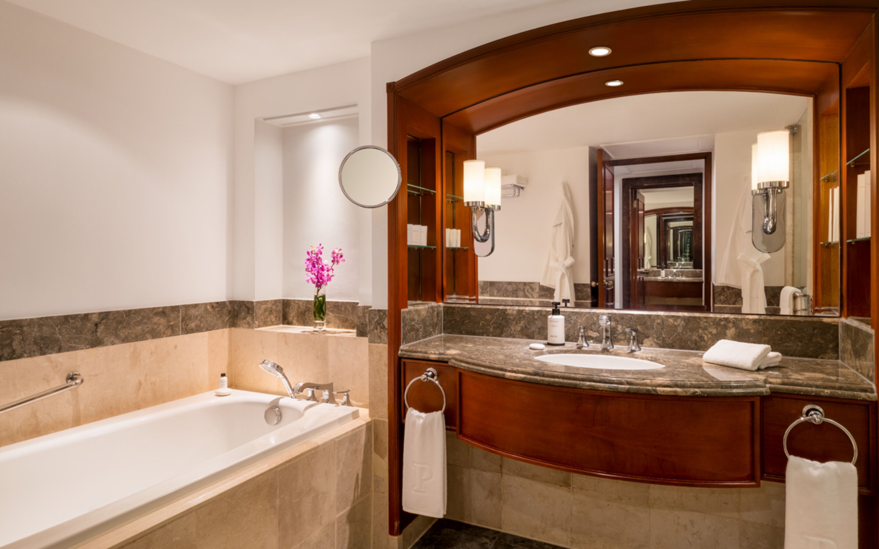 A bathroom with a bathtub, a sink, a mirror, and a towel rack.