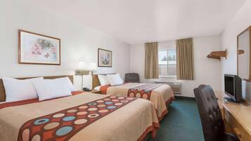 Quarto de hotel com duas camas, uma mesa de trabalho, televisão, uma cadeira e janela com cortinas.