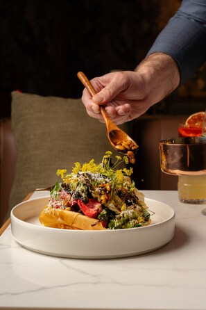 A plate of food with a variety of vegetables and a wooden spoon. - Novotel Sydney City Centre (Sydney)