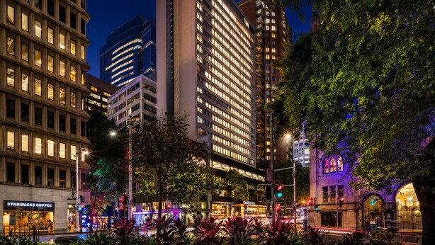 A modern hotel with multiple floors, a prominent sign, and a well-lit facade. - Novotel Sydney City Centre (Sydney)