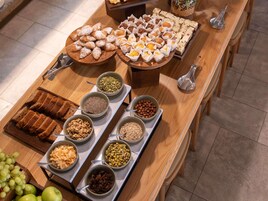 A buffet table with various food items and utensils.