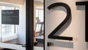 A hotel room number 21 with a sign indicating 'The Studio' and a glass door. - Novotel Sydney City Centre (Sydney)