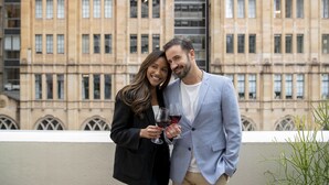 A couple holding wine glasses on a balcony with a building in the background. - Novotel Sydney City Centre (Sydney)