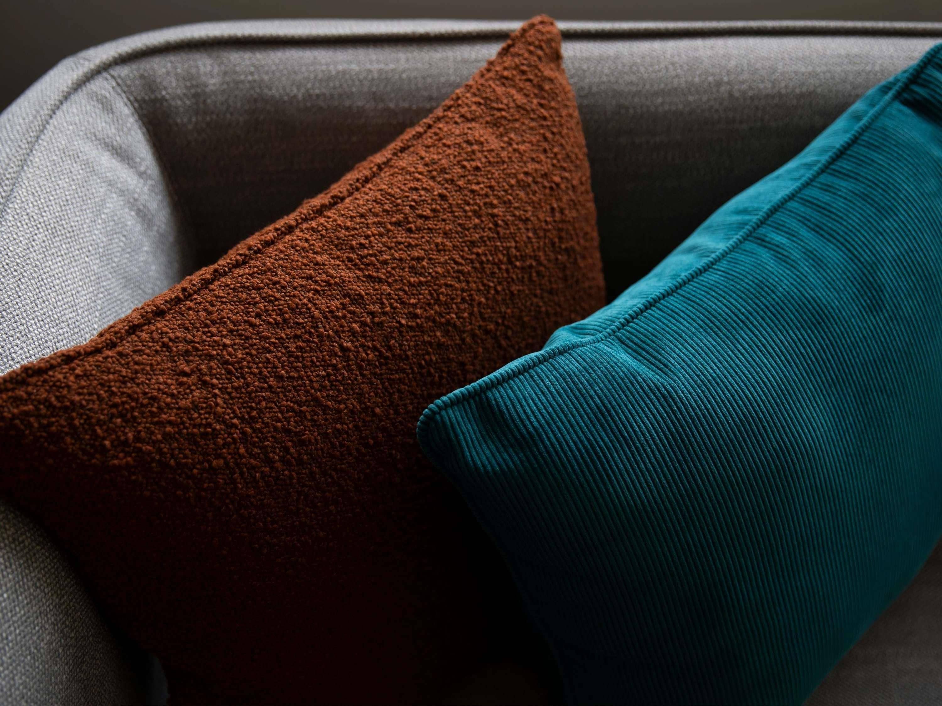 Primer plano de dos almohadas sobre un sofá.