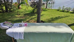 A massage table set up outdoors with a magazine, a bottle, and a flower on it. - Sina Suites Cancún - Adults Only (Cancun)