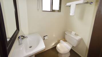 A bathroom with a sink, toilet, and a window.