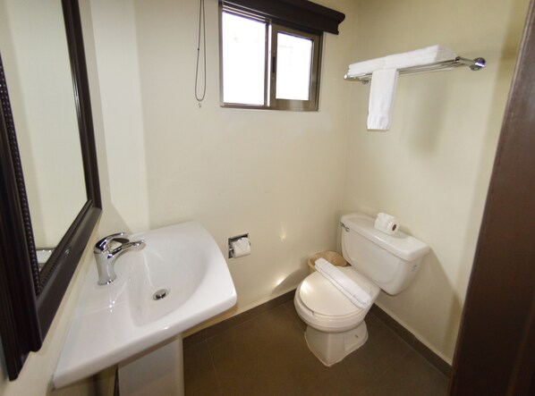 A bathroom with a sink, toilet, and a window. - Sina Suites Cancún - Adults Only (Cancun)