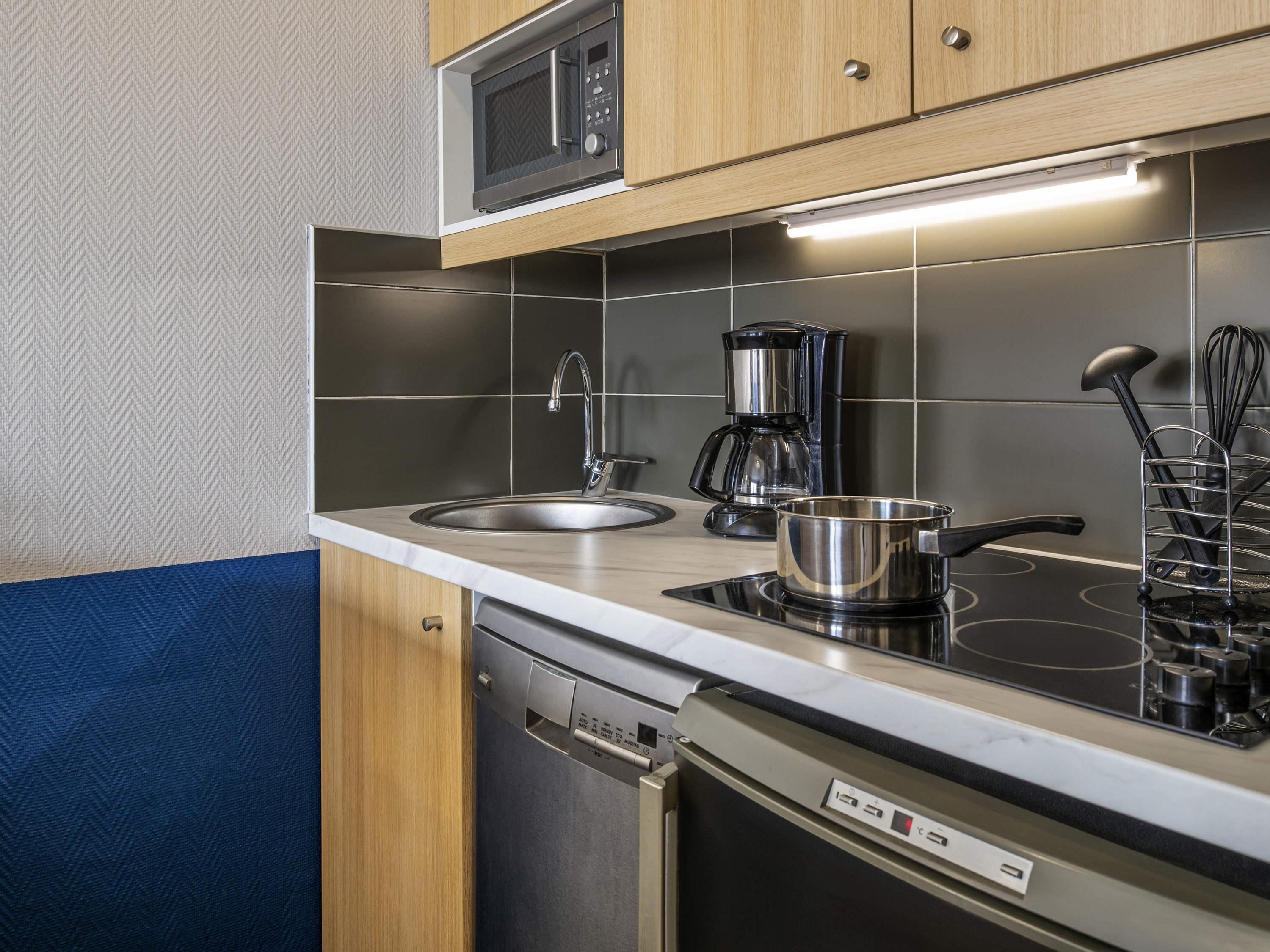 A modern kitchen with a built-in microwave, coffee maker, and electric stove.