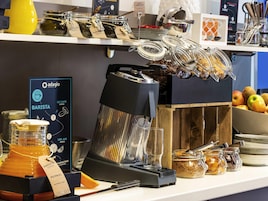 Una estación de café con una máquina de café, tarros de café y un letrero que dice 'Oadagio Barista'.