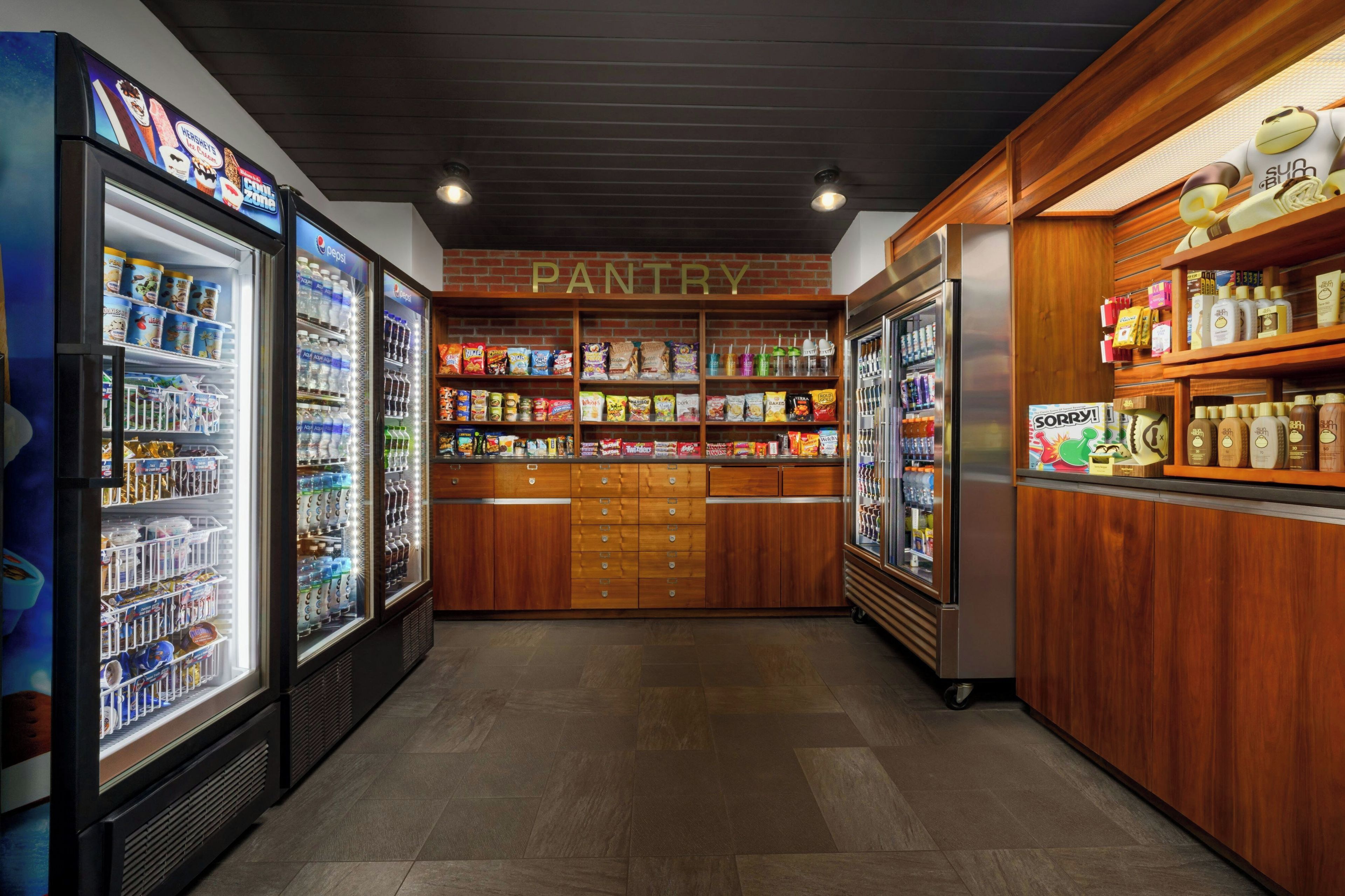 A pantry area with refrigerated shelves stocked with beverages and snacks.
