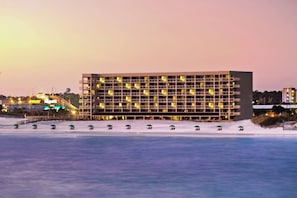 Een meerlaags hotel met een modern architectonisch ontwerp, voorzien van balkons en uitzicht op het water.