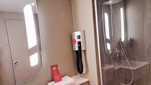 A bathroom with a sink, mirror, towel dispenser, and a shower with a glass door. - ibis Toulon La Seyne Sur Mer (La Seyne-sur-Mer)