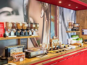Een ontbijtbuffet met diverse keuzes, zoals fruit, ontbijtgranen en gebak.