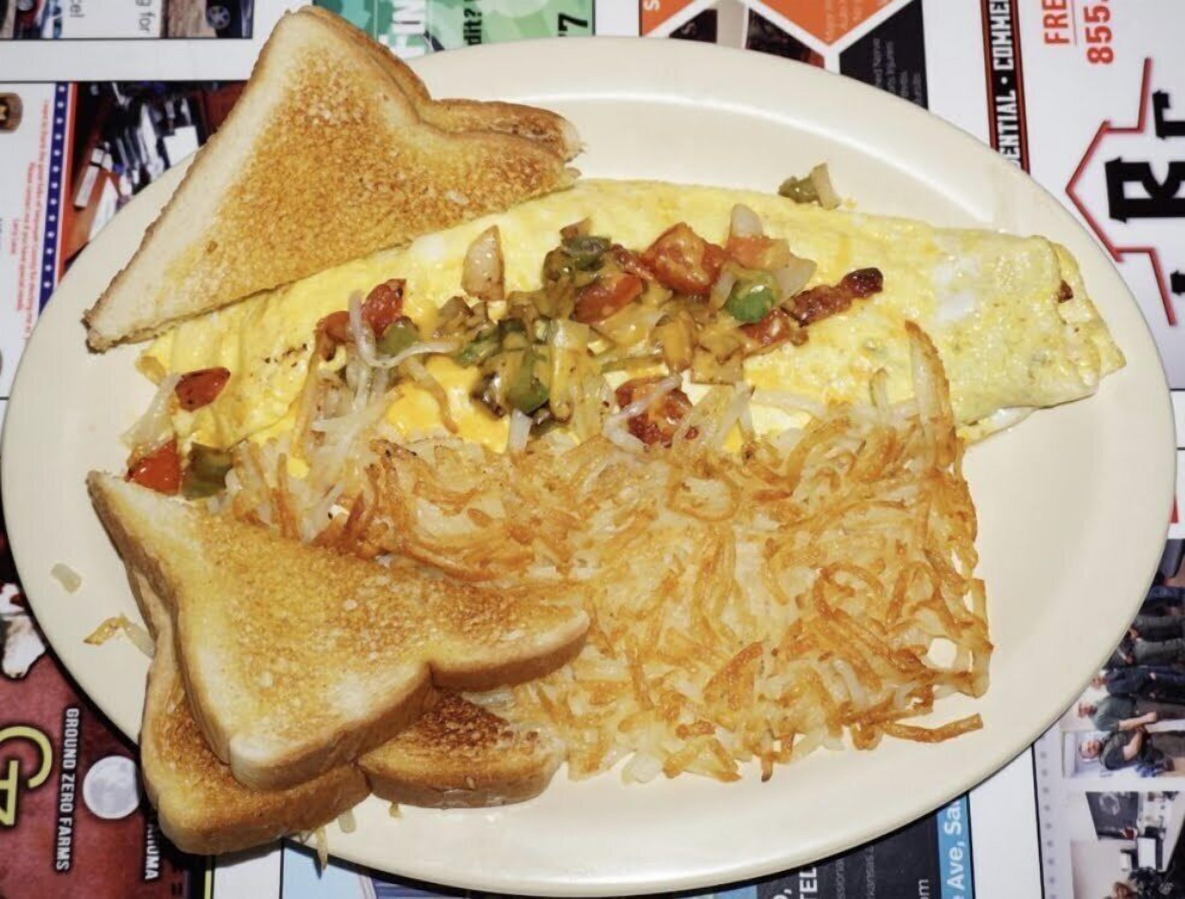 A plate with toast, hash browns, and an omelet with vegetables.