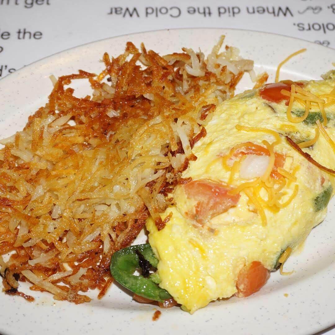 A plate with hash browns and an omelette.