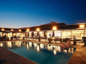 Una piscina al aire libre de temporada, sombrillas