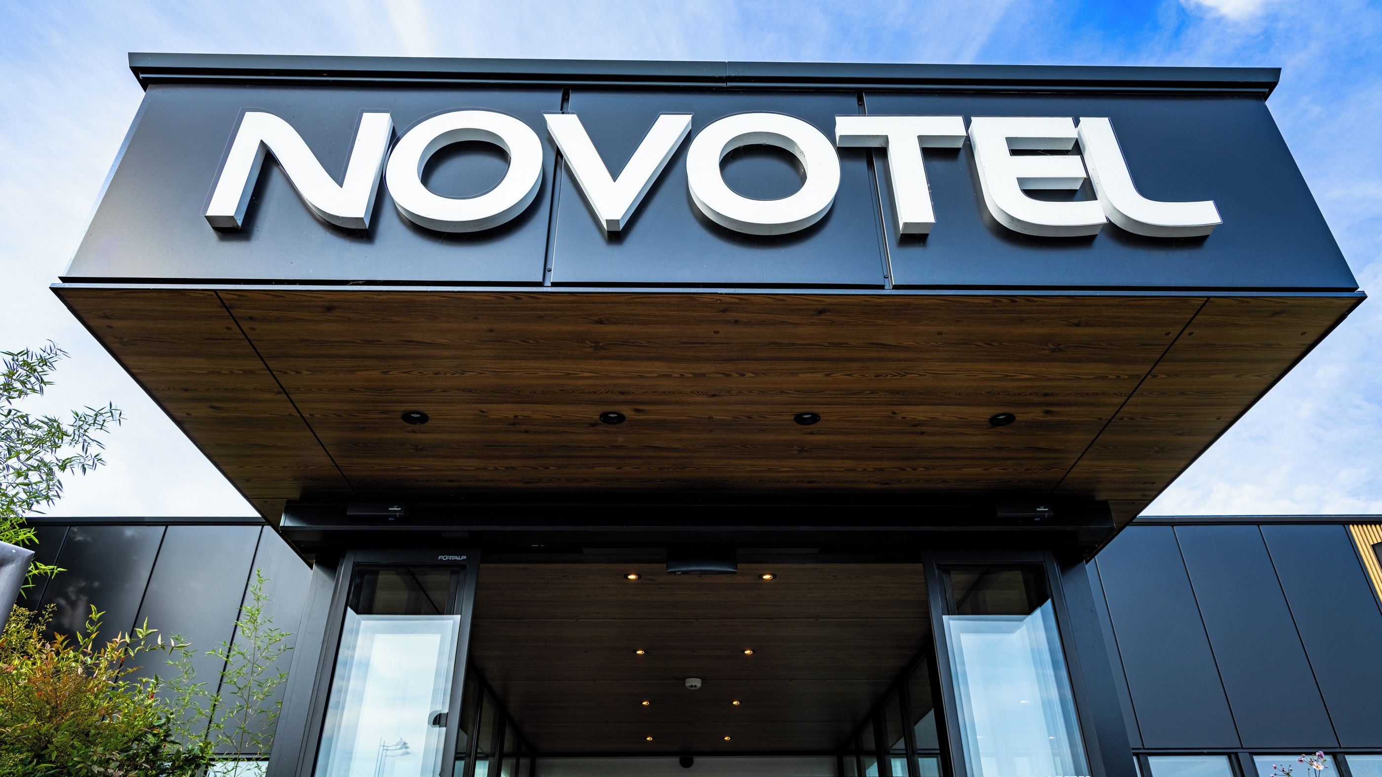 A modern hotel entrance with a prominent 'NOVOTEL' sign.