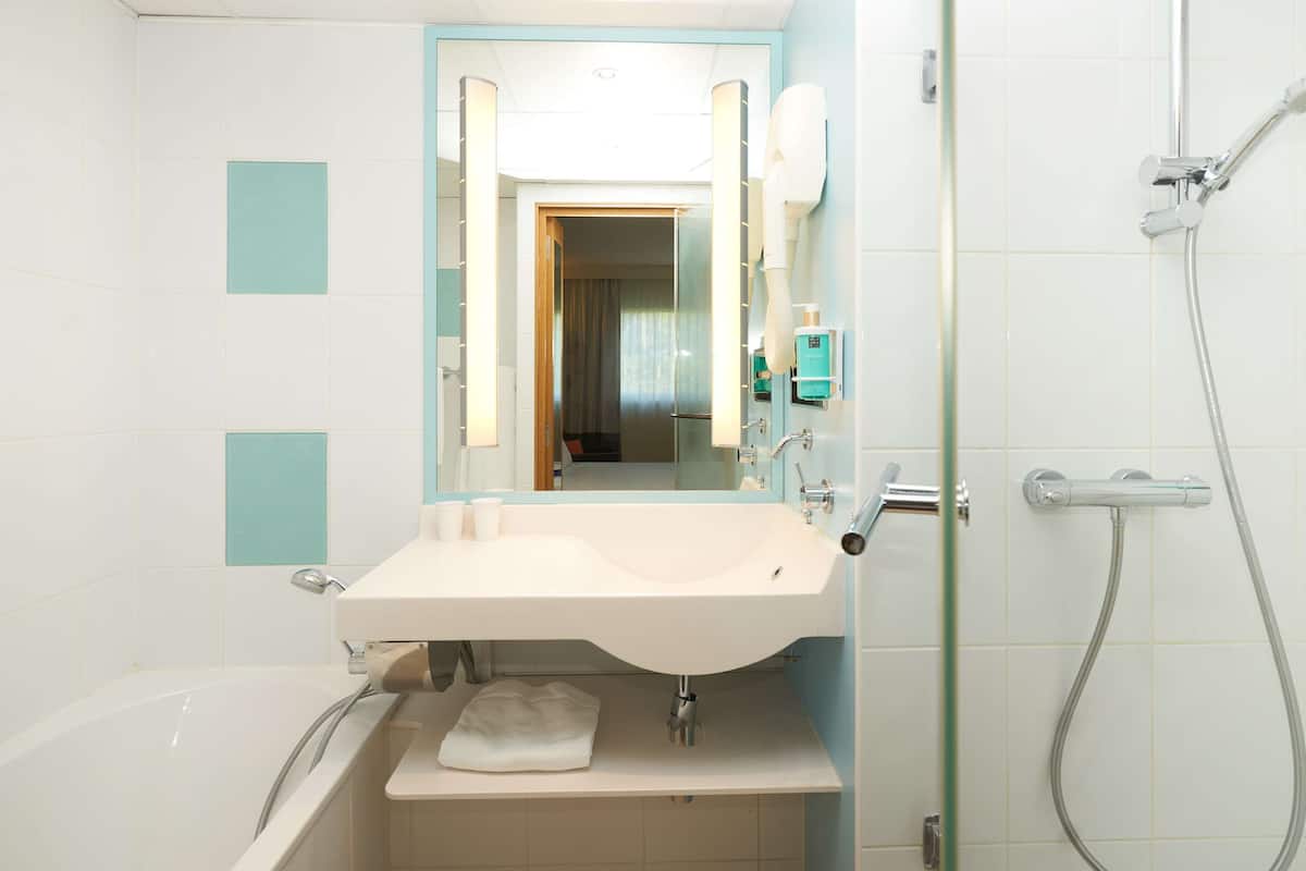 Enjoy a refreshing shower in the bathroom with a glass-enclosed shower area and handheld showerhead.