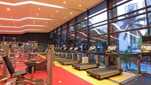 A gym with treadmills, weight machines, and a red carpet.