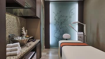 Une salle de bain moderne avec un grand miroir, un lavabo et un lit.