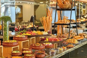Un bufé con diferentes alimentos y una planta decorativa.