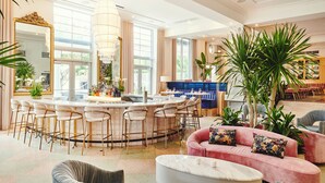 A spacious hotel lobby with a central bar area, seating arrangements, and large windows allowing natural light. - Park Central South Beach (Miami Beach)