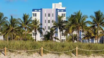 A beachfront hotel with a modern design, featuring multiple floors and a prominent blue and white color scheme.