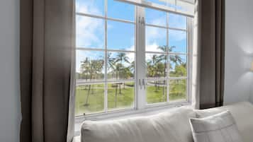 Una habitación con un ventanal grande, un sofá y cortinas.