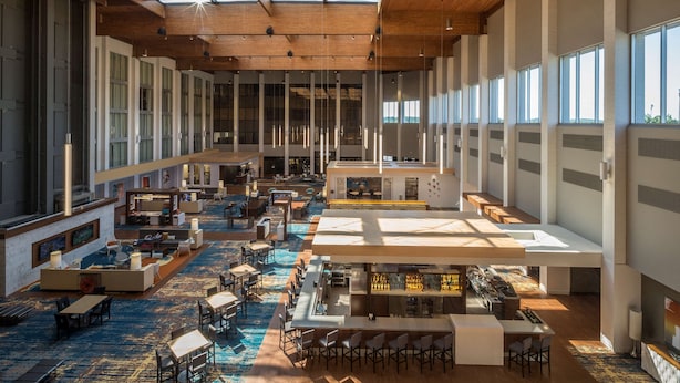 A spacious hotel lobby with multiple seating areas, a bar, and large windows allowing natural light. - DoubleTree by Hilton Pittsburgh - Cranberry (Mars)