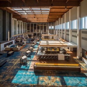 A spacious hotel lobby with multiple seating areas, a bar, and large windows allowing natural light. - DoubleTree by Hilton Pittsburgh - Cranberry (Mars)