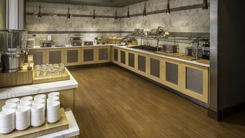 A modern kitchen with marble countertops, wooden cabinets, and a variety of cooking appliances.